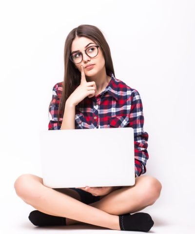 A young girl sitting on the floor with a laptop